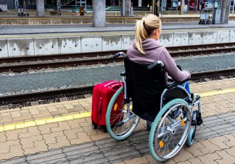 イギリスの鉄道駅で電車を待つ車椅子女性
